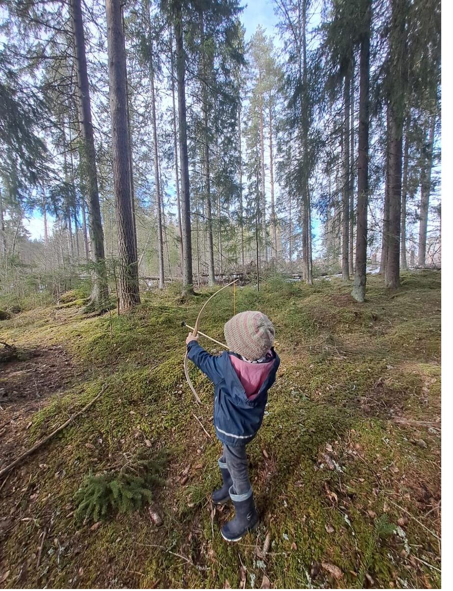 Kind im Frühlingswald mit Bogen